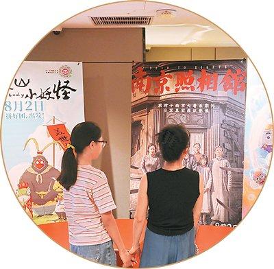 市民在浙江省嘉兴市南湖区一家影城观看电影海报。金鹏 摄（人民图片）